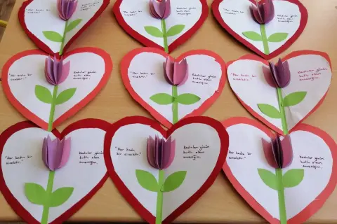 Manualidades de **actividades día de la madre**: corazones de papel con tulipas y mensajes para mamá.