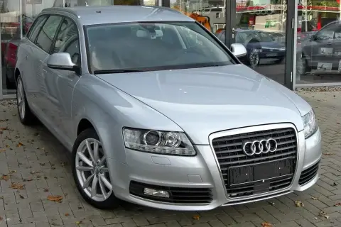 Srebrne Audi A6 C6 2.7 TDI Avant zaparkowane przed salonem.