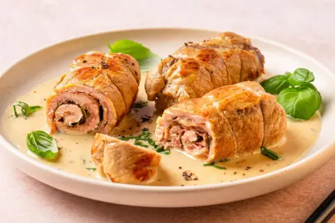 Kalbsrouladen in cremiger Sauce mit Basilikum garniert.