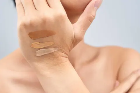 Tre campioni di fondotinta su una mano, utili per capire come scegliere il sottotono della pelle.