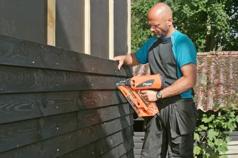 Man monterar liggande panel med spikpistol.