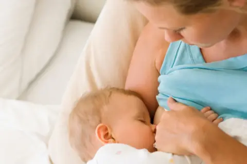 Matka karmi piersią dziecko, które wydaje się mieć brak pokarmu po porodzie.