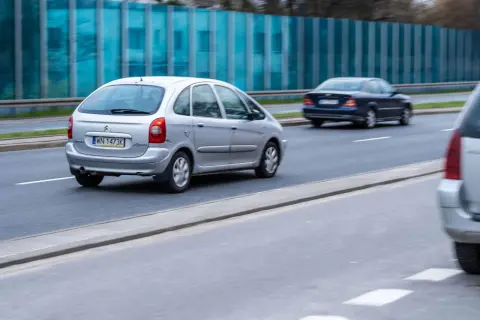 Srebrny Citroën Xsara Picasso jedzie po drodze, obok niebieski sedan.