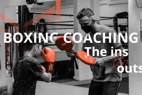 A coach demonstrates boxing techniques to a young boxer, highlighting the ins and outs of coaching boxing.