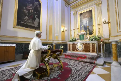 Papa se arrodilla ante el altar. La imagen ilustra la diferencia entre cristiano y católico, mostrando la devoción en la iglesia.