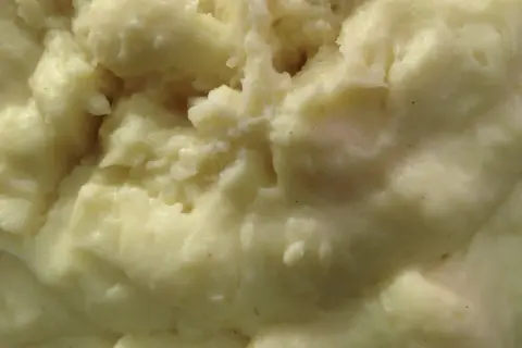 Un primo piano di cremoso purè di patate, pronto per essere gustato.