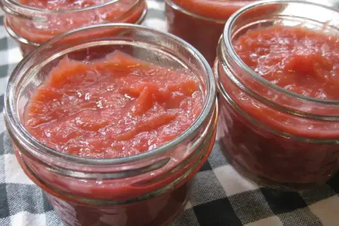 Fyra små glasburkar fyllda med hemgjord rabarbermarmelad. Perfekt för frukostmackan eller till desserten.