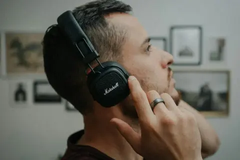 Mężczyzna w słuchawkach Marshall, skupiony na dźwiękach 432 hz.