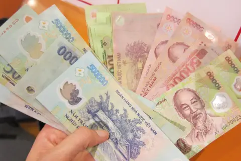 W ręce trzymam plik banknotów. To waluta Wietnamu, w tym banknoty 500 000 i 10 000 dongów.