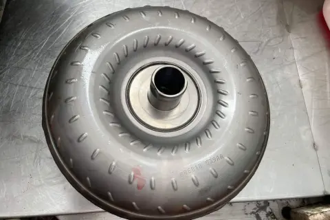 Metalowy element, jeden z rodzajów sprzęgieł, z widocznym numerem seryjnym.