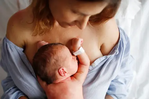Matka tuli noworodka na piersi. To piękny obraz początku połogu, czasu regeneracji i budowania więzi.