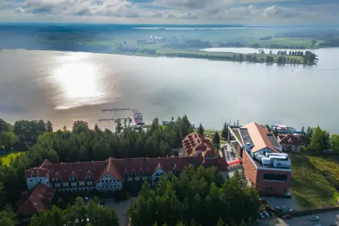 Hotel Robert's Port Lake Resort & Spa na Mazurach, z widokiem na jezioro i przystań. Warto sprawdzić opinie przed rezerwacją.