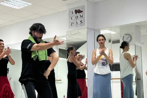 Clase de sevillanas rápidas con un instructor masculino y varias mujeres practicando.
