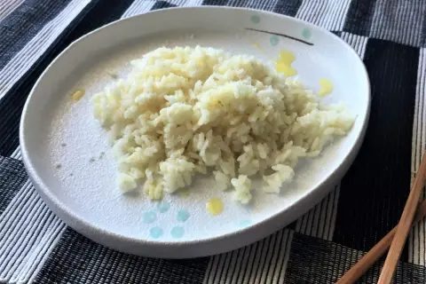 Piatto di riso in bianco, semplice e profumato, pronto per essere gustato con le bacchette.
