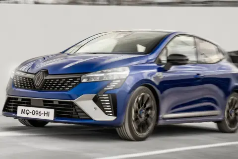 Niebieski Renault Clio 2024 pędzi po drodze, jego nowoczesny design i dynamiczna sylwetka przyciągają wzrok.