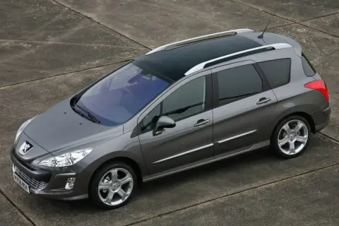 Szary Peugeot 308 SW z 2011 roku z panoramicznym dachem, zaparkowany na betonowej nawierzchni.