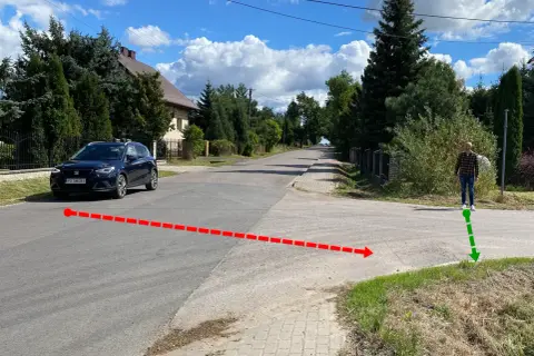 Czerwona linia pokazuje, jak zatrzymać samochód przed skrzyżowaniem. Zielona strzałka wskazuje miejsce, gdzie stoi człowiek.