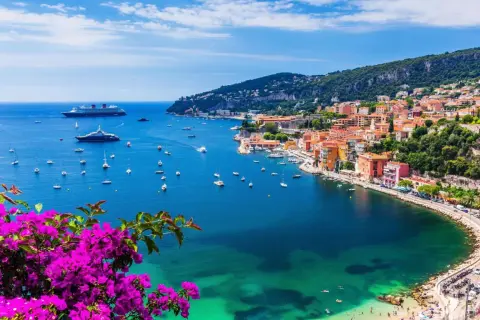 Bunte Küstenstadt mit Yachten im azurblauen Meer. Ein perfektes Bild für die besten Reiseziele im September weltweit.