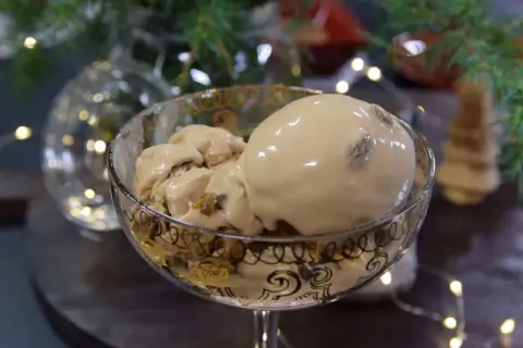 En skål med krämig kokosglass, perfekt för ett hemmagjort kokosglass recept. Julbelysning och gran i bakgrunden.