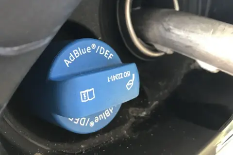 Niebieski korek wlewu AdBlue z napisem "AdBlue®/DEF" i symbolem ostrzegawczym. Sprawdź, ile adblue zostało.