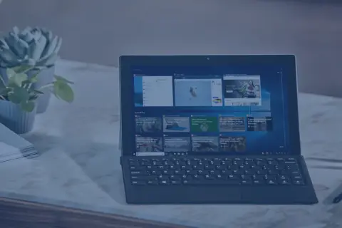 Nowoczesny laptop z klawiaturą i ekranem dotykowym, obok rośliny i stosu papierów. Idealny do pracy, gdy środek trwały od jakiej kwoty jest potrzebny.
