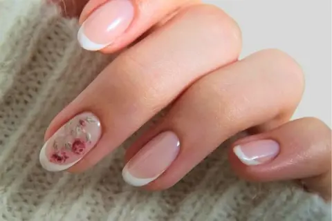 Delikatne paznokcie boho z subtelnym motywem kwiatowym na jednym z paznokci. Klasyczny french manicure w letnim wydaniu.