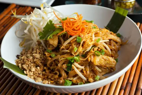 Pyszne danie co to pad thai: makaron ryżowy z kurczakiem, kiełkami fasoli mung, orzeszkami ziemnymi i szczypiorkiem.