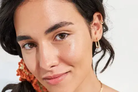 Rostro de mujer con piel luminosa y saludable, realzando el efecto del squalane que es un hidratante natural.