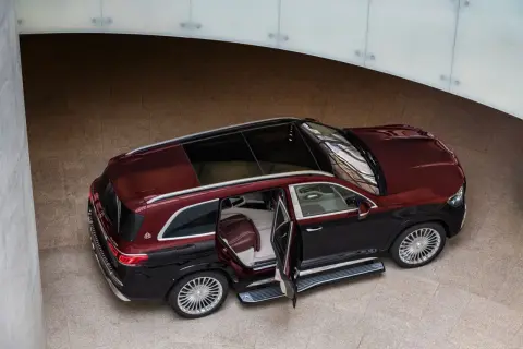 Elegancki, dwukolorowy Maybach GLS 600 z otwartymi drzwiami, prezentujący luksusowe wnętrze.
