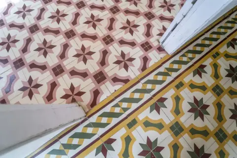 Un beau mélange de travertin et de carreaux de ciment aux motifs géométriques et floraux, créant une ambiance chaleureuse et authentique.
