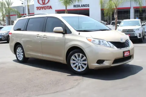 Złoty minivan Toyota Sienna 2025 na tle salonu Toyota.