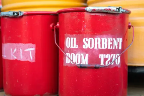 Czerwone wiadra z napisem "OIL SORBENT BOOM T270" i "KIT" gotowe do użycia. Dysperbent czeka na akcję.