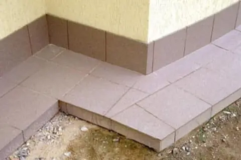 Wykonana opaska wokół domu z płytek ceramicznych, chroniąca fundament przed wilgocią.