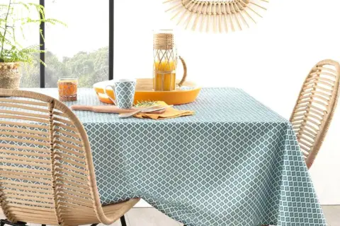 Table dressée avec une nappe à motifs géométriques bleus et blancs. Idéal pour savoir quelle couleur de nappe choisir pour un style frais et naturel.