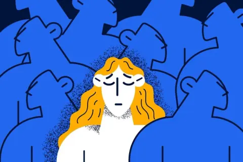 Eine Frau mit blonden Haaren und traurigem Gesichtsausdruck steht inmitten einer blauen Masse von Menschen, die sie zu ignorieren scheinen.