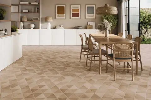Un salon lumineux avec un carrelage non salissant au motif géométrique discret. Une table en bois et des chaises en rotin complètent l'ensemble.