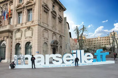 Une lettre géante extérieur "Marseille.fr" trône sur une place, invitant à découvrir l'actualité de la ville.