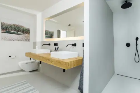 Modernes **Bad ohne Fliesen** mit Doppelwaschtisch auf Holzkonsole, wandhängendem WC und ebenerdiger Dusche.