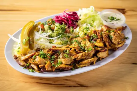En tallrik med saftig kyckling shawarma, ris, sallad, pickles och en krämig sås. Perfekt för ett snabbt och gott shawarma recept.