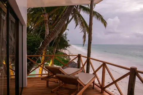 Relaks na tarasie z widokiem na plażę i ocean. Dwa leżaki czekają na gości, którzy chcą poczuć klimat pili pili zanzibar.