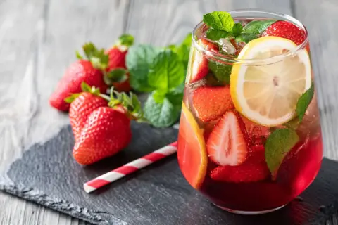 Erfrischende alkoholfreie Erdbeerbowle mit frischen Erdbeeren, Zitrone und Minze in einem Glas.