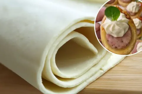 Ciasto francuskie zwinięte w rolkę i małe przekąski z kiełbasą w cieście francuskim.