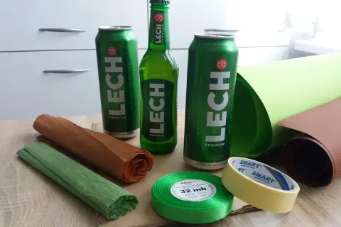 Jak zrobić prezent z piwa? Potrzebne będą puszki i butelka piwa Lech, ozdobny papier, wstążka i taśma.
