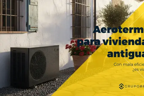 Unidad exterior de aerotermia junto a una casa antigua. ¿Son viables las mentiras de la aerotermia en viviendas antiguas con mala eficiencia?