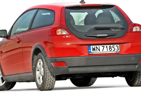 Czerwony volvo hatchback C30 z polskimi tablicami rejestracyjnymi WN 71853, widok od tyłu.
