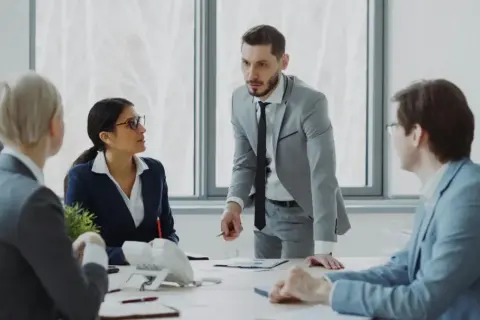 Biznesmeni dyskutują przy stole w nowoczesnym biurze.