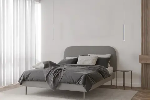 Minimalistyczna sypialnia z łóżkiem i dwoma lampami wiszącymi tuba, które dodają nowoczesnego charakteru.