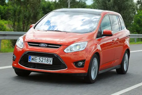 Pomarańczowy Ford C-Max na drodze. Wiele osób szuka ford c max opinie przed zakupem.
