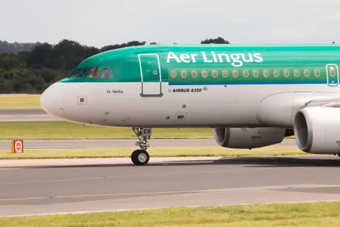 Samolot Airbus A320 irlandzkich linii lotniczych Aer Lingus z napisem "St. Nathy" na kadłubie, kołujący po płycie lotniska.