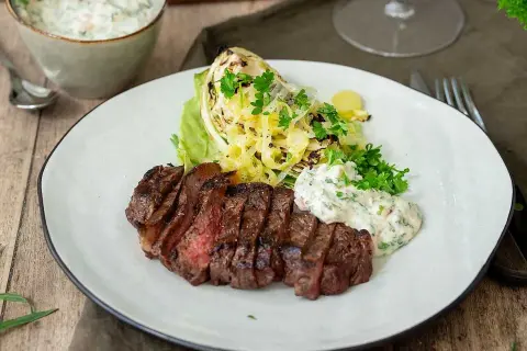 Perfekt grillad ryggbiff med krispig kål och en krämig sås. En härlig måltid att grilla ryggbiff till.